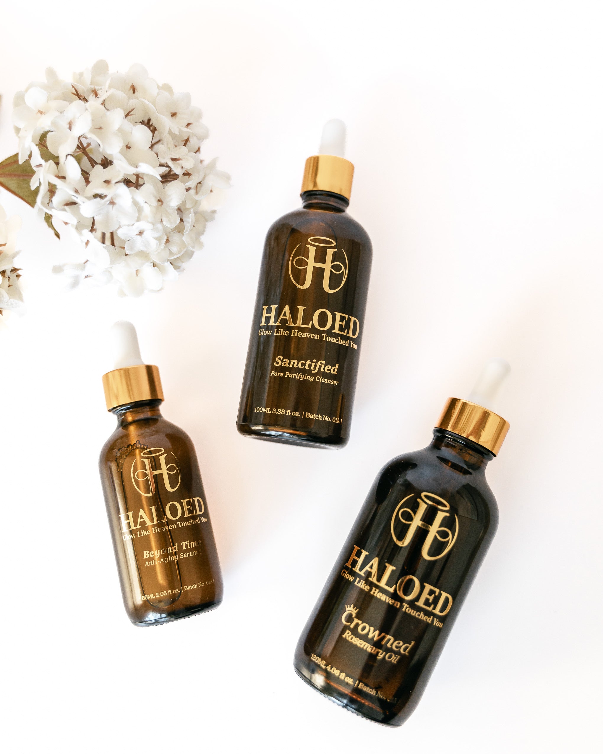Three bottles of Haloed products on a white background with decorative elements.