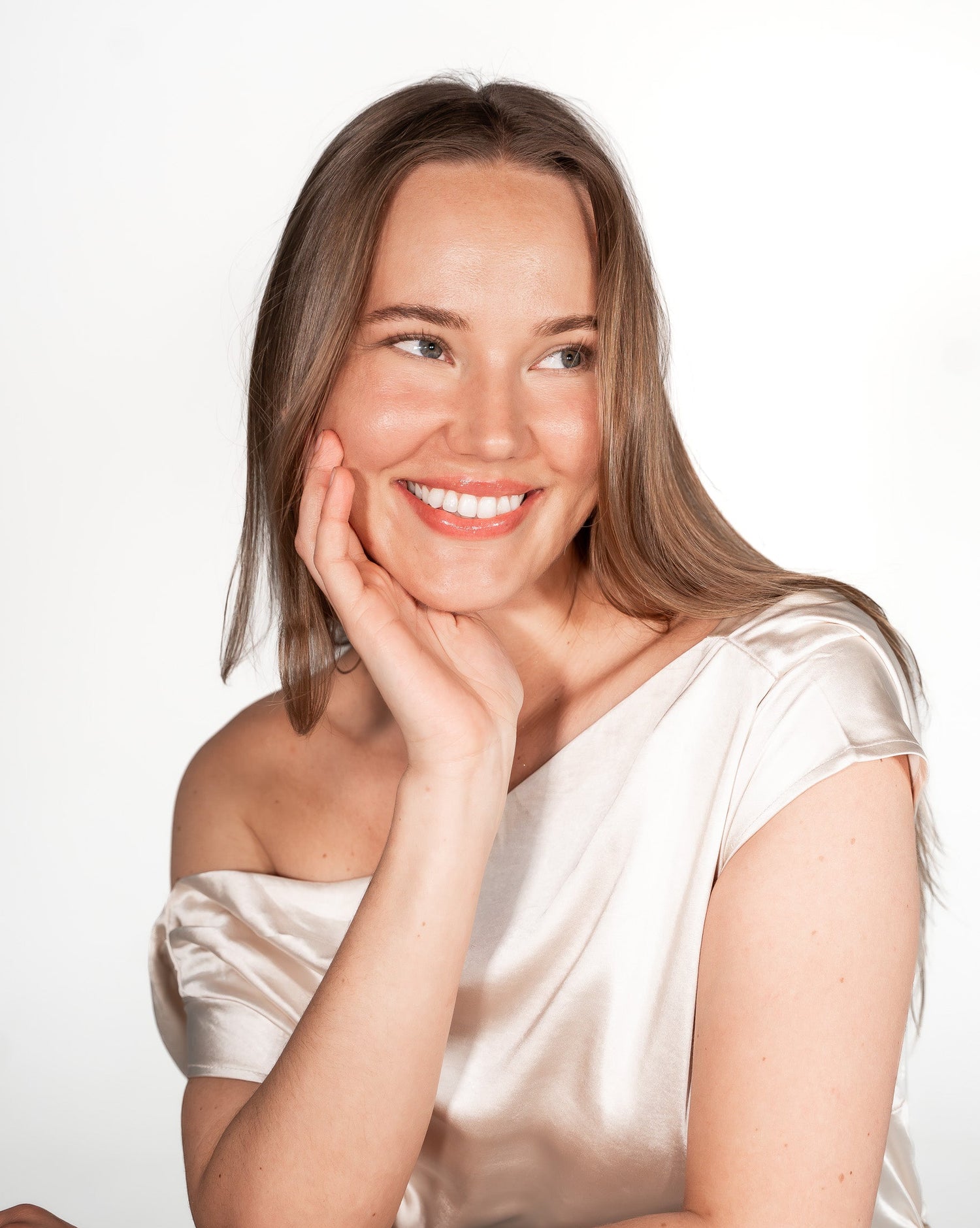 Woman in a white dress posing against a white background