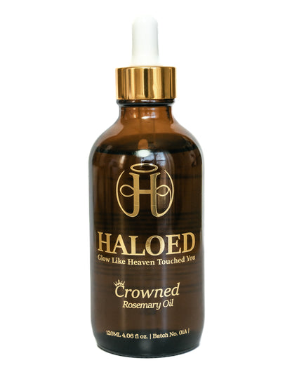 Brown bottle of Haloed Crowned Rosemary Oil with gold cap on a white background